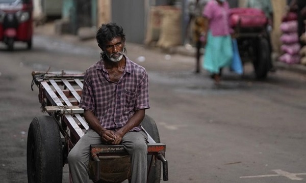 Người đàn ông ngồi chờ việc tại một chợ bán buôn ở thủ đô Colombo, Sri Lanka, hồi tháng 6.