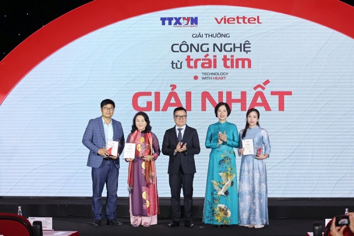 Tổng Giám đốc TTXVN Vũ Việt Trang và Tổng Biên tập báo Nhân Dân Lê Quốc Minh trao giải Nhất cho các tác giả đoạt giải.